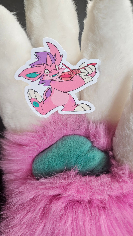 Rhubarb's fursuit paw holding the sticker